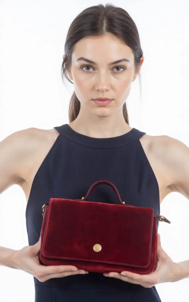 A French female model with a Velvet bag, wearing a dress, against a white background, in a front   facing close   up